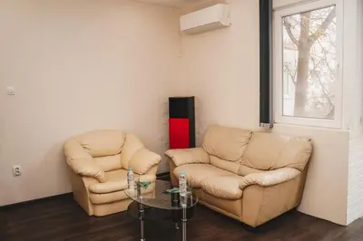 two leather chairs and a table in a room at Sunny Corner Apartment in Plovdiv