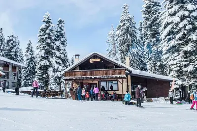 a group of people standing outside of a building in the snow at Private apartments in Flora Residence in Borovets