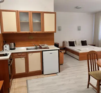 a room with a kitchen and a bed in the background at Private apartments in Flora Residence in Borovets