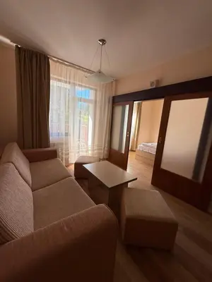 a living room with a couch and a table at Private apartments in Flora Residence in Borovets