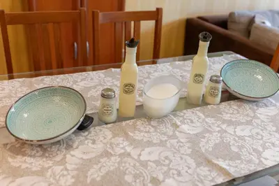 a table with three bottles and plates on it at Megy's 3 Bedroom Central Apartment near NDK in Sofia