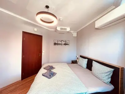 a bedroom with a bed with a wooden headboard at The Bansko Retreat in Bansko