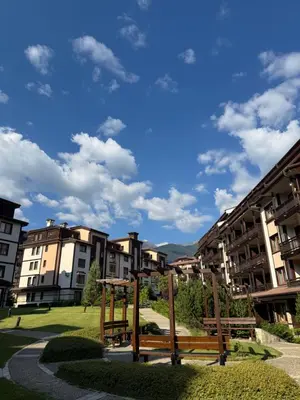 a park with two benches in front of buildings at The Bansko Retreat in Bansko