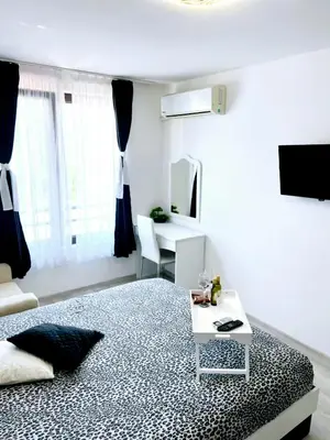 a white room with a bed and a table at Deva Apartments in Sandanski