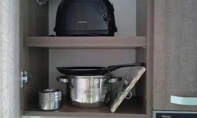 a shelf with a pot and pans and a toaster at Deva Apartments in Sandanski