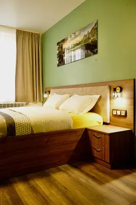 a bedroom with a large bed and a window at Къща за Гости Тодор in Shiroki Dol