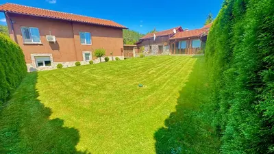 a large yard with a house and a hedge at Къща за Гости Тодор in Shiroki Dol