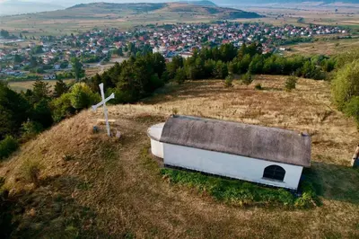 an old barn on a hill with a town at Къща за Гости Тодор in Shiroki Dol