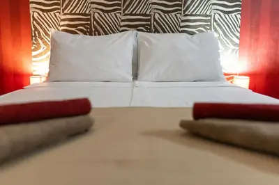 a bedroom with a bed with white sheets and pillows at Megy's Top Central Studio Next to NDK in Sofia