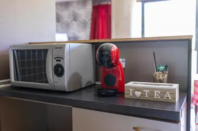 a microwave sitting on top of a counter with a red appliance at Megy's Top Central Studio Next to NDK in Sofia