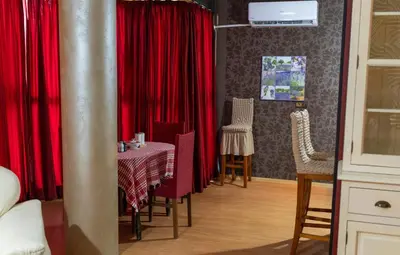 a dining room with red curtains and a table and chairs at Megy's Top Central Studio Next to NDK in Sofia