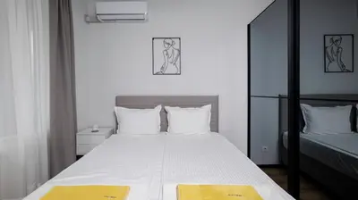 a bedroom with a bed with white sheets and yellow towels at Fresh & Modern Apartment with Balcony by Flat Mаnager in Sofia