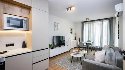 a living room with a couch and a tv at Fresh & Modern Apartment with Balcony by Flat Mаnager in Sofia