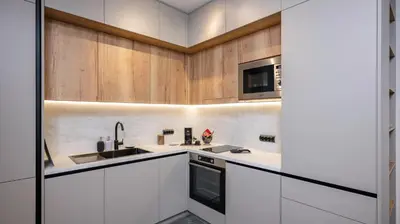 a kitchen with white cabinets and a sink and a microwave at Fresh & Modern Apartment with Balcony by Flat Mаnager in Sofia