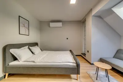 a bedroom with a bed and a couch and a chair at La Shara Building in Sofia