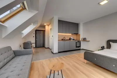 a bedroom and living room with a bed and a kitchen at La Shara Building in Sofia