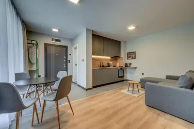 a living room and kitchen with a table and chairs at La Shara Building in Sofia