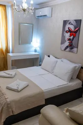 a bedroom with a large white bed and a mirror at Megy's 3rd Top Central Room in Sofia