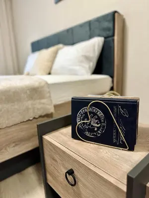 a book sitting on a table next to a bed at The Central Suite in Petrich