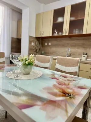 a dining table with flowers on it in a kitchen at The Central Suite in Petrich