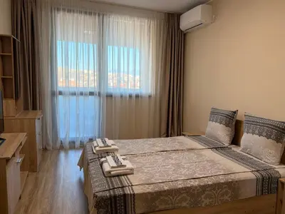 a bedroom with a large bed with a window at Asen Tsvetkov Apartment in Sandanski