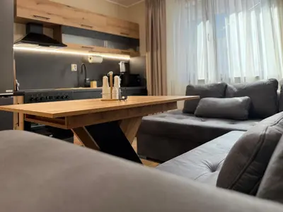 a living room with a wooden table and a couch at Asen Tsvetkov Apartment in Sandanski