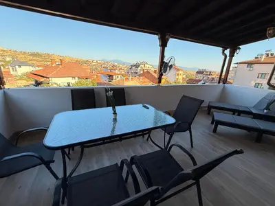 a table and chairs on a balcony with a view at Asen Tsvetkov Apartment in Sandanski
