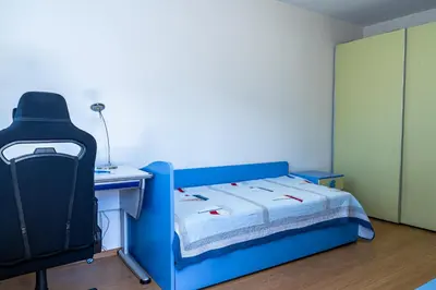 a bedroom with a blue bed and a desk and a chair at Evgeny's Stylishly Designed 2 Bedroom Apartment plus Garage! in Sofia