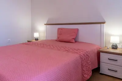 a bedroom with a pink bed with a pink bedspread at Evgeny's Stylishly Designed 2 Bedroom Apartment plus Garage! in Sofia