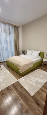 a bedroom with a bed and a large window at Green apartment Velingrad in Velingrad