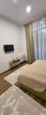 a bedroom with a bed and a flat screen tv at Green apartment Velingrad in Velingrad