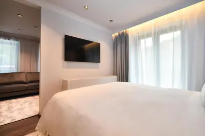 a white bedroom with a large bed and a couch at Villa Rossa Luxury & Spa Residence in Narechenski Bani