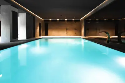 a swimming pool with blue lighting in a building at Villa Rossa Luxury & Spa Residence in Narechenski Bani