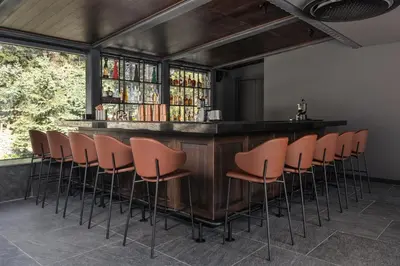 a bar with a bunch of stools in a room at Villa Rossa Luxury & Spa Residence in Narechenski Bani