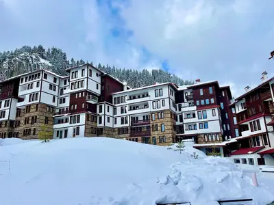 a group of buildings with snow in the foreground at Tulip Studio Deluxe, Grand Resort Pamporovo in Pamporovo