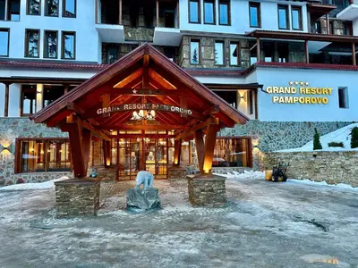 a building with a wooden structure in the snow at Tulip Studio Deluxe, Grand Resort Pamporovo in Pamporovo