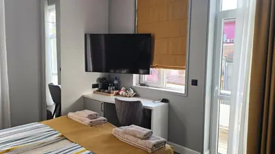 a bedroom with a bed and a desk with towels at FS Apartments Romantic Kapana View Room in Plovdiv