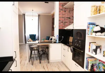 a kitchen with white cabinets and a brick wall at FS Apartments Kapana Boutique Family Stay in Plovdiv