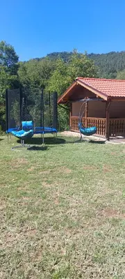 two swings in a yard next to a building at Двете къщи село Бели осъм in Beli Osŭm