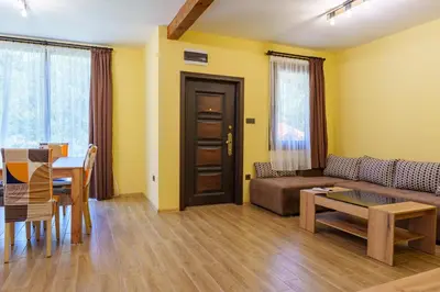 a living room with a couch and a table at Двете къщи село Бели осъм in Beli Osŭm