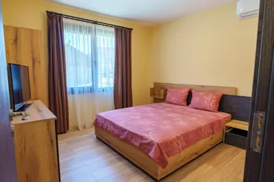 a bedroom with a bed and a television in it at Двете къщи село Бели осъм in Beli Osŭm