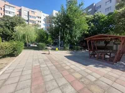 a picnic shelter in a park with trees and buildings at Strumsko Stay in Blagoevgrad