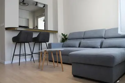a living room with a blue couch and two stools at cosy apartment in Sofia