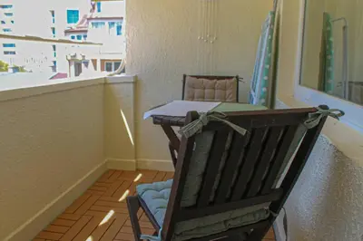 a wooden rocking chair in a room with a table at cosy apartment in Sofia