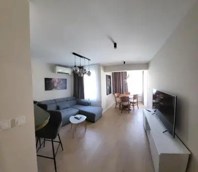 a living room with a blue couch and a tv at cosy apartment in Sofia