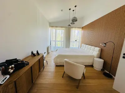 a bedroom with a bed and a desk with a chair at White & Wood Suite C302, at Euphoria SPA Borovets in Borovets