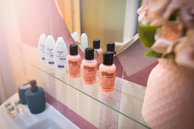 a bathroom mirror with four bottles of soap on a sink at Alexandra's City Center Apartment I in Sofia