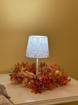 a lamp sitting on top of a table with autumn leaves at Central Family Residence in Sofia