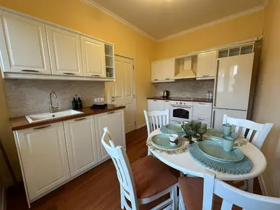 a kitchen with a table and chairs in a kitchen at Central Family Residence in Sofia