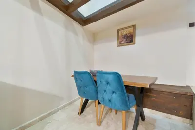 a dining room with a wooden table and two blue chairs at Blue House in Plovdiv